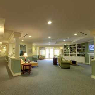 A spacious and well-lit lobby area with comfortable seating and carpeted flooring.