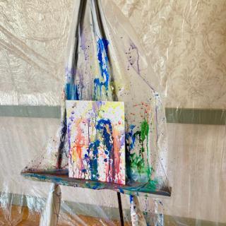 A vibrant abstract painting displayed on an easel in a creative workspace.