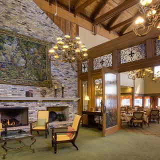 Cozy rustic lounge with a fireplace, wooden beams, and comfortable seating.
