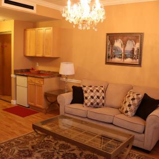 A cozy living room with a sofa, coffee table, and a chandelier overhead.