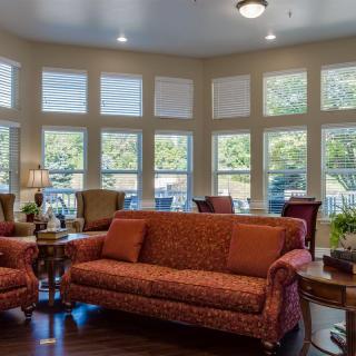 A cozy living room with large windows and comfortable seating.