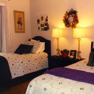 A cozy bedroom with two neatly made beds and warm lighting.