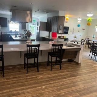 A modern kitchen and dining area with a sleek counter and wooden flooring.