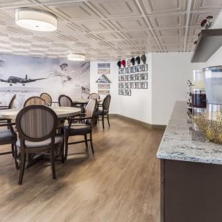A modern dining area with elegant chairs and tables, featuring aviation-themed wall art.