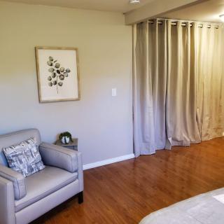 A cozy bedroom with a chair and decorative elements.