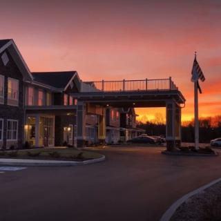A building with a covered entrance set against a vibrant sunset sky.