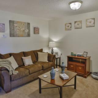 A cozy living room with a comfortable sofa, coffee table, and tasteful wall decor.
