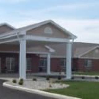 A modern building with a covered entrance and white columns.