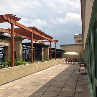 A serene rooftop space with a pergola and seating area, perfect for relaxation.