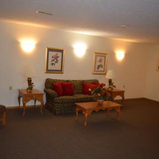 A cozy living room featuring a patterned sofa, coffee tables, and decorative artwork.