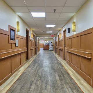 A well-lit hallway in a healthcare facility, featuring wooden paneling and a modern design.