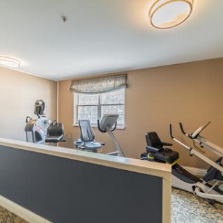 A modern fitness center featuring various workout machines in a well-lit indoor space.