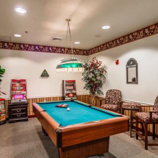 A cozy game room with a pool table and comfortable seating.