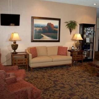 A cozy living room with a sofa, lamps, and a large painting on the wall.