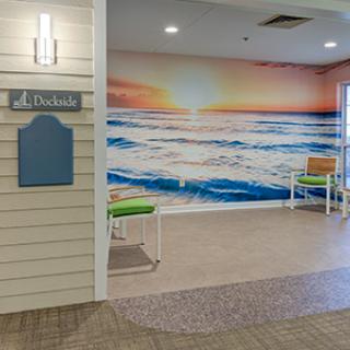 A welcoming lobby area featuring a stunning beach sunset mural with seating arrangements.