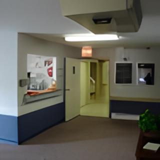 A hospital hallway featuring an exit sign and multiple doors.