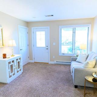 A cozy living room with a sofa, large window, and modern decor.