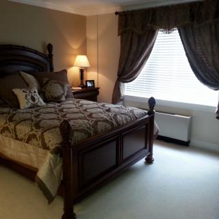 A cozy bedroom with elegant wooden furniture and soft lighting.