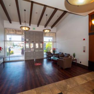 A modern lobby with wood flooring, stylish lighting, and a comfortable waiting area.