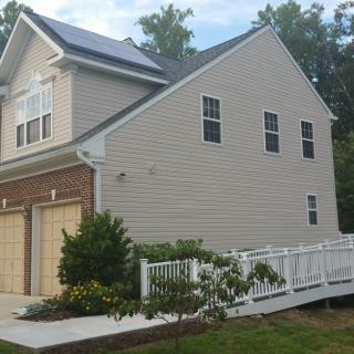 A modern two-story house with a ramp leading to the entrance.