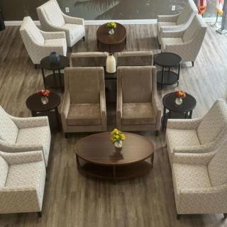 A neatly arranged seating area with chairs and coffee tables in a lobby or waiting room.