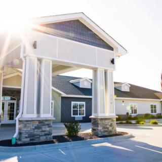 A modern building entrance with large columns and sunlight shining through.