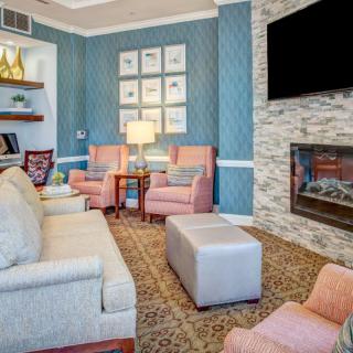 A cozy living room with elegant furniture, a fireplace, and a mounted television.