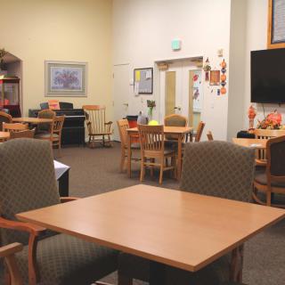 A cozy community space with tables and chairs arranged for gatherings.