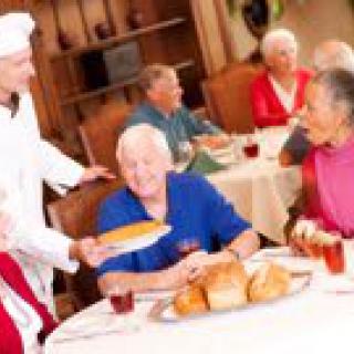Seniors enjoying a meal at a restaurant with friendly service.
