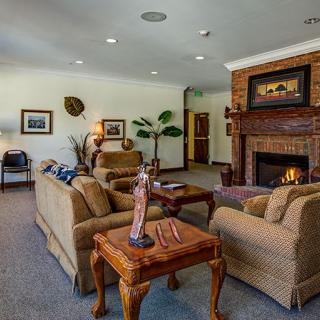 A cozy living room with a traditional design featuring a fireplace, comfortable seating, and elegant decor.