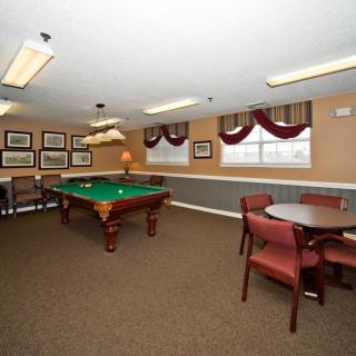 A cozy game room featuring a pool table, seating area, and warm lighting.