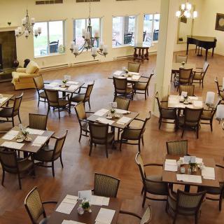 An empty dining room with neatly set tables and chairs, featuring a spacious interior.