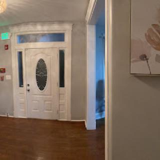 A welcoming entrance featuring a decorative door and elegant wooden flooring.