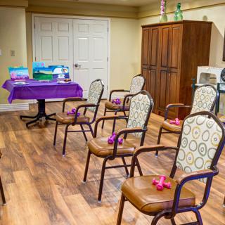 A meeting room with chairs arranged in rows facing a table with colorful decorations.