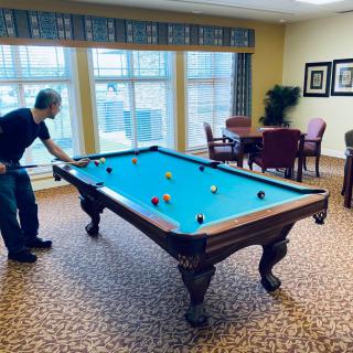 A person playing billiards in a cozy game room.