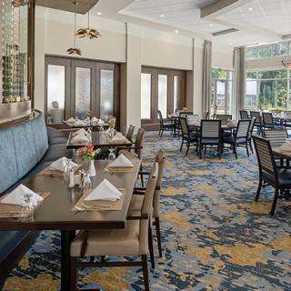 An elegant restaurant dining area with neatly arranged tables and chairs, featuring tasteful interior design.