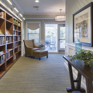 A cozy reading nook with bookshelves, an armchair, and a well-lit ambiance.