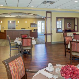 A cozy dining area with neatly arranged tables and chairs, featuring warm decor.