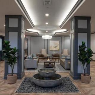 A modern lobby with a central fountain and seating area.