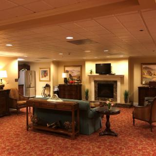 A warmly lit lobby featuring comfortable seating, a fireplace, and decorative artwork.