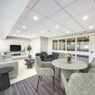 A modern lounge and dining area featuring contemporary furniture and ample lighting.
