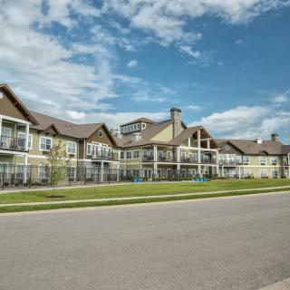 A view of a suburban residential building with multiple units and a clear blue sky above.