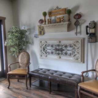 A cozy waiting area featuring vintage decor, comfortable seating, and decorative wall elements.