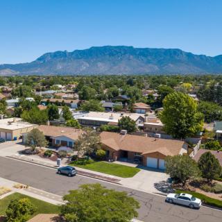 Aerial view of a suburban neighborhood with houses and mountains in the background.