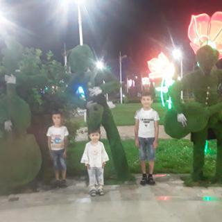A fun night at the park with children posing alongside whimsical topiary figures.