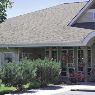 A residential house with a gabled roof and surrounding greenery.