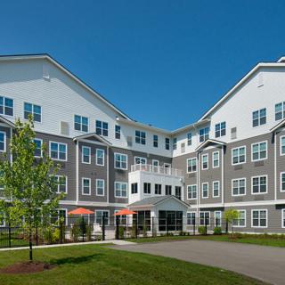 A modern apartment complex with a landscaped exterior on a sunny day.