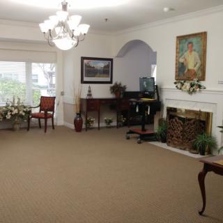 A spacious living room featuring elegant furniture, a fireplace, and artwork on the walls.