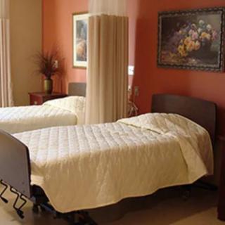 A cozy interior with two neatly made beds, divided by a privacy curtain.