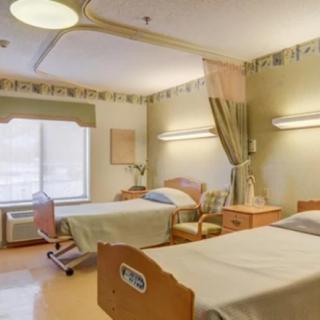 A hospital room with two beds and medical equipment.